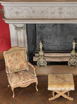 La pièce avant la découpe&nbsp;: un fauteuil et le tabouret devant la cheminée.